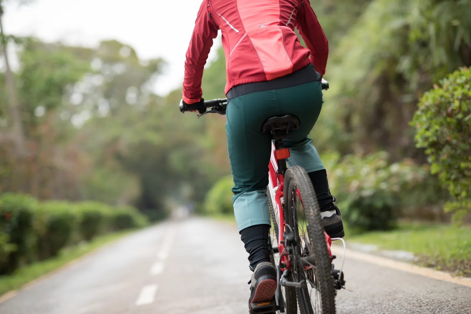 Mujer en bicicleta por un camino de un parque